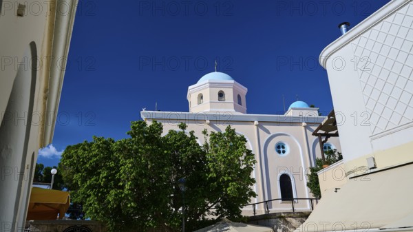 Mediterranean church with blue dome and green trees under a blue sky, Agia Paraskevi Church, Kos