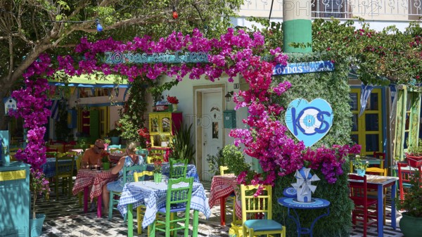 Cosy taverna with flowers and colourful furniture, sunny and welcoming atmosphere, Platia Diagora,