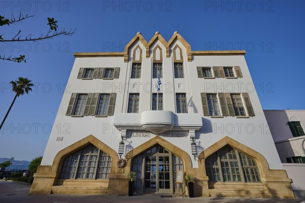 Historic building with striking architecture and symmetrical windows against a blue sky, boutique