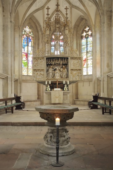High altar and baptismal font of the Romanesque St. Mary's Church, interior view, colourful church