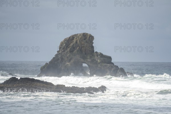 A rugged coastal landscape with rocks in the sea and a cloudy sky, Indian Beach, Oregon, USA, North