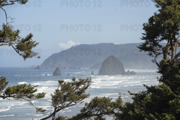 Sunny beach with large rocks in the sea and clear blue sky, peaceful and relaxing atmosphere,