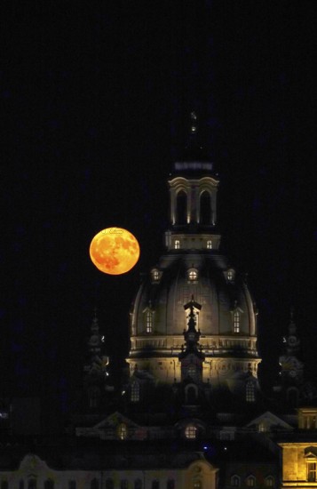 Glowing strawberry moon on 11 June 2025 next to the dome of the Church of Our Lady Dresden, Saxony,