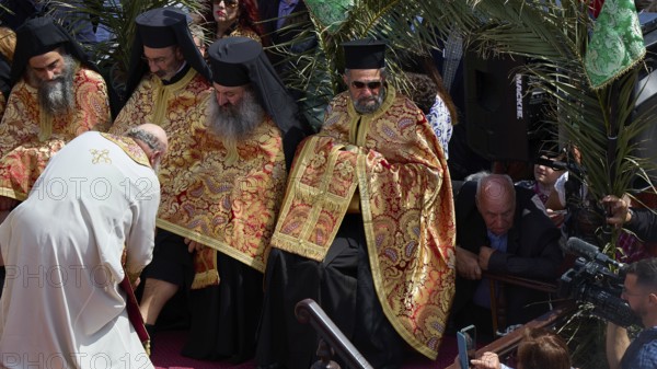 Priests in golden robes perform a religious ritual in front of a gathered crowd, Orthodox ceremony,