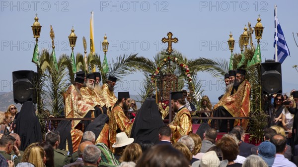 A procession of priests in golden robes, surrounded by palms and religious symbols, holds an