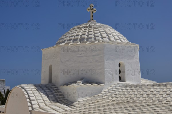 Cross-domed church of Panagia Diasosousan, church with white dome and cross against a blue sky,