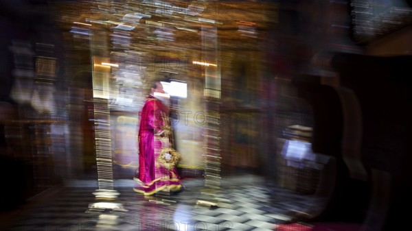 Zoodochou Pigis Monastery, Blurred image of a priest in red robes in a gold-decorated church