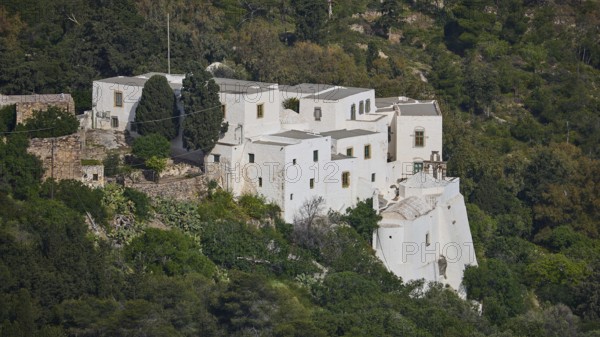 Monastery on a green hill with trees and surrounding nature, Monastery of the Revelation, Moni tis