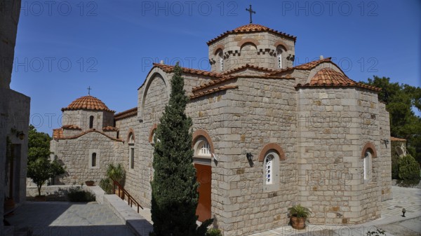 Large stone church building with several domes and a cross in the courtyard, woman's monastery,