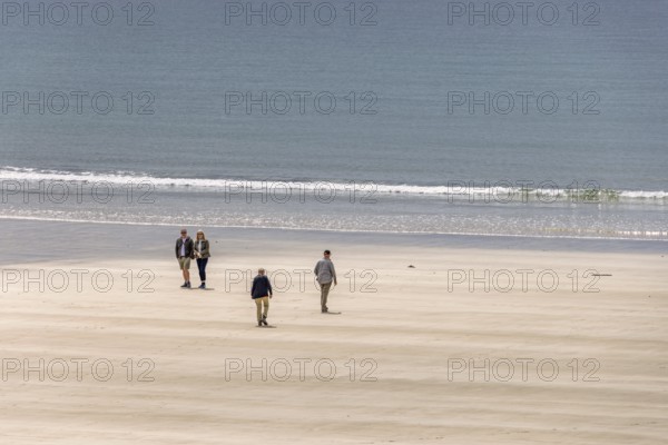 People walking on a sand beach by the sea a sunny summer day, Crozon peninsula, Bretagne, France