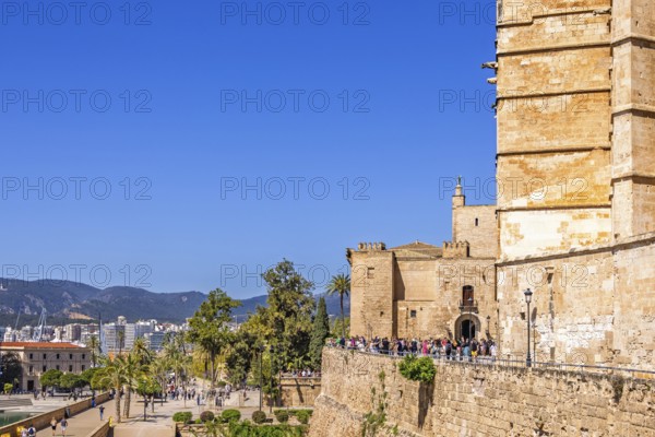 View at Palma city with tourists in the sunshine outside the famous old Palma Cathedral, Palma de