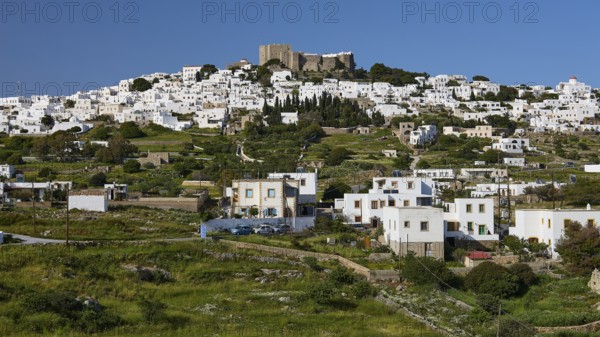 Whitewashed Mediterranean houses on a hill, crowned by an old fortress, Monastery of St John the