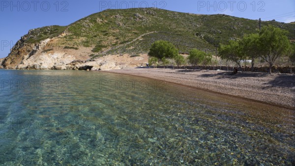 Quiet beach with green hill in the background and clear blue water, Lambi Beach, Lambi Bay, Patmos,