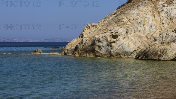 Rocky coast with calm, clear water under a blue sky, Lambi Beach, Lambi Bay, Patmos, Dodecanese,
