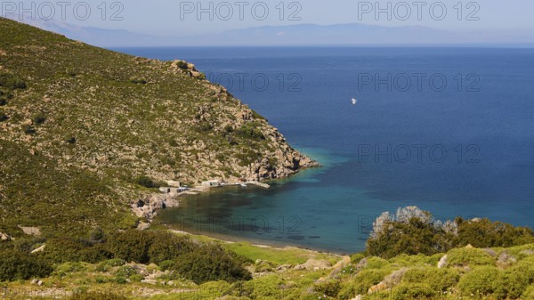 Sweeping views of turquoise blue sea and green hills with a narrow stretch of coastline,