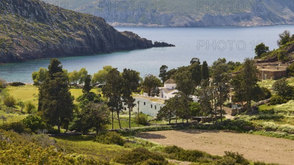 Small village on a rocky coast, surrounded by trees and blue sea, Limoni Kalogiron Monastery,