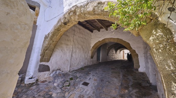Old stone alleyway with arches and shade, offering a historic and cosy atmosphere, Chora, UNESCO