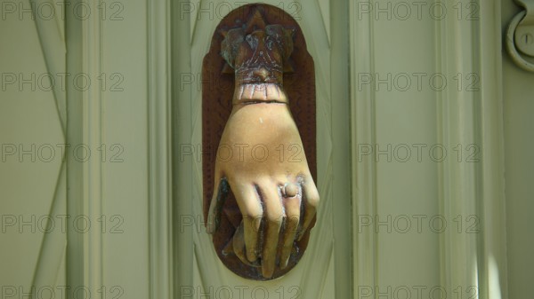 Detail of an ancient, hand-shaped door knocker on a green door, Chora, UNESCO World Heritage Site