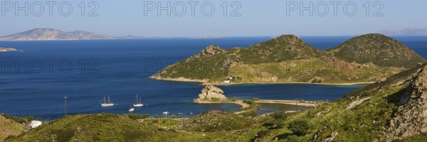 Panoramic view of sailing boats in front of mountains and a blue lake on an island, Rock of