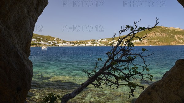 View through a rock opening over the blue sea and the coastal town, Cave, Grikos, Rock of