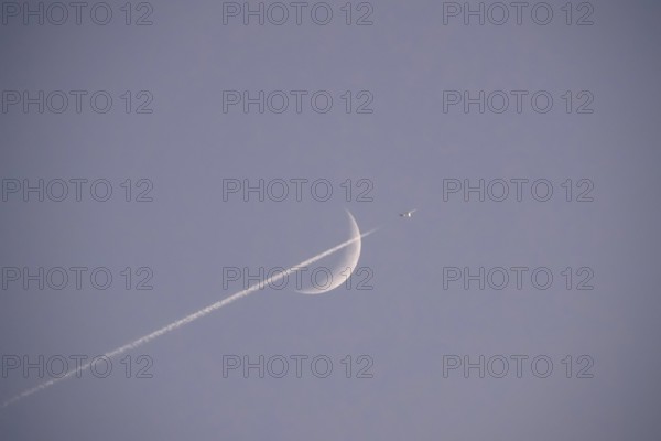 Evening sky with crescent moon and aeroplane, Germany