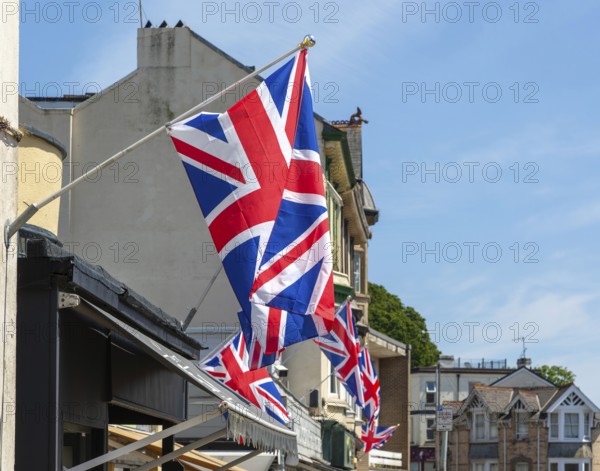 Union Jack flags on shops in street of historic buildings, The Strand, Dawlish, south Devon,