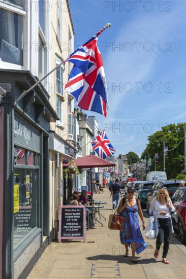 Union Jack flags on shops in street of historic buildings, The Strand, Dawlish, south Devon,