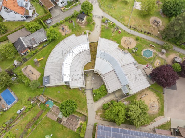 Building complex with an innovative architectural design and surrounding play and green areas,