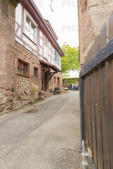 Narrow alley with traditional half-timbered houses and stone walls in a historic neighbourhood,