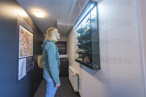 Glass showcase with stones and information boards in a museum room, family festival in Neubulach,