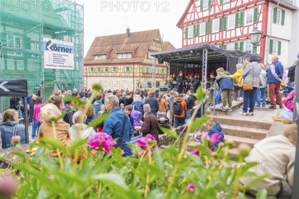 Colourful street festival with lots of people, stage and traditional houses, family festival in