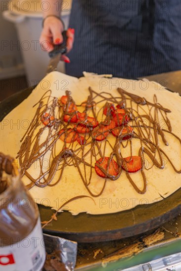Crêpe with chocolate and strawberries being prepared on a hotplate, Calw railway station festival,