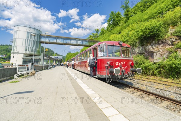 Red train stands on the platform in bright daylight, Calw railway station festival, Black Forest,
