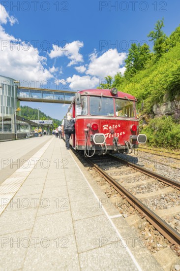 Red train waiting on the track under a blue sky, Calw railway station festival, Black Forest,