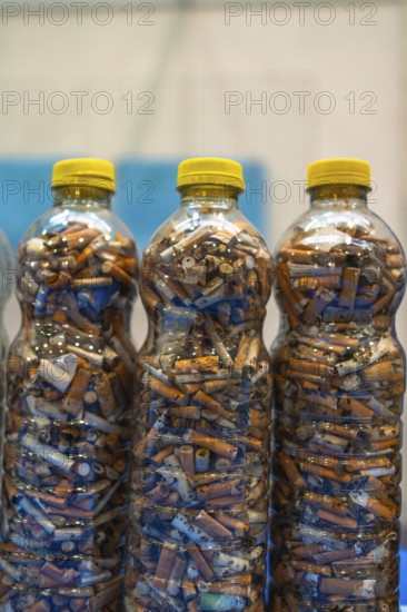 Plastic bottles are filled with discarded cigarette butts, highlighting the pervasive issue of