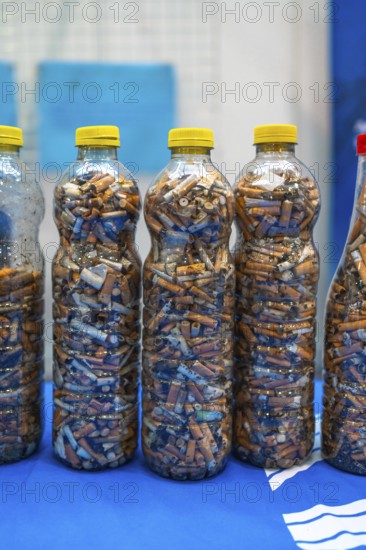 Plastic bottles filled with cigarette butts collected during a beach cleanup, highlighting