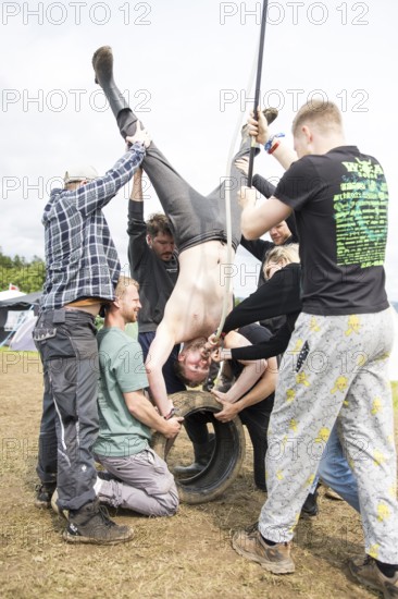 Festival visitors drinking from a funnel on a campsite at the Rock am Ring Festival on Saturday,