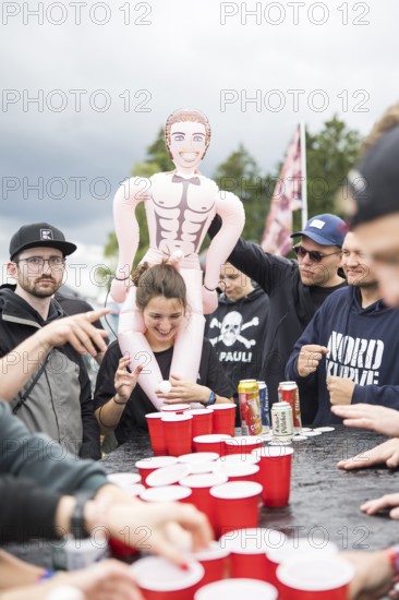 Festival visitors play a drinking game on a campsite at the Rock am Ring Festival on Saturday,
