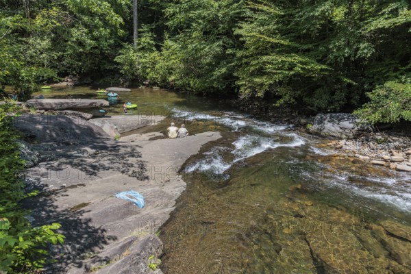 Senior couple watches children floating down the Hiawassee River on inflatable rafts near