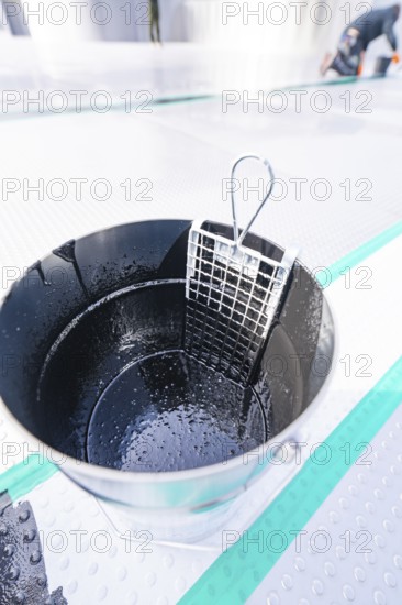 Close-up of a wet metal bucket with grid insert, shiny and detailed, renewal of the swimming lines,