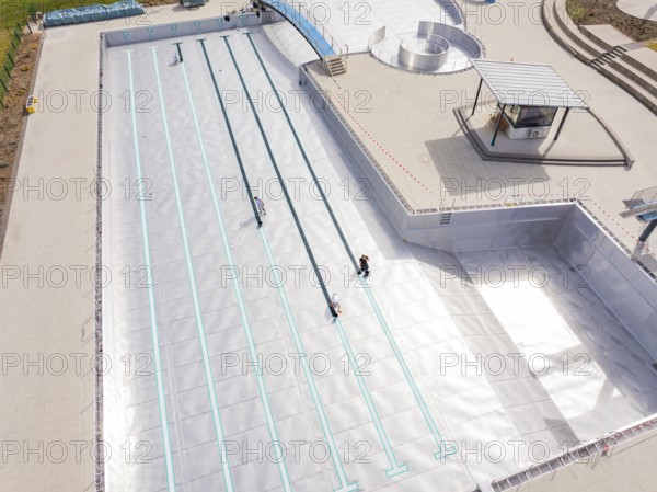 High-angle shot of an empty swimming pool under construction with metal walls, renewal of the