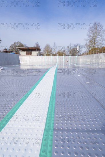 View along an empty swimming pool with striking stripes in the sun, renewal of the swimming lines,