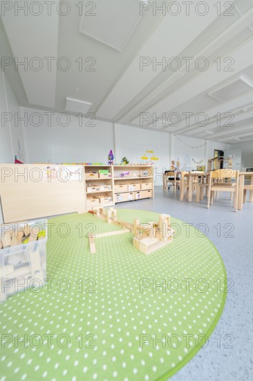 Kindergarten with green carpet and building blocks on the floor, transitional containerised daycare