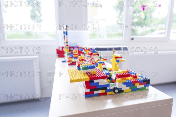 Colourful Lego models on a table in front of a sunny window, transitional daycare centre in