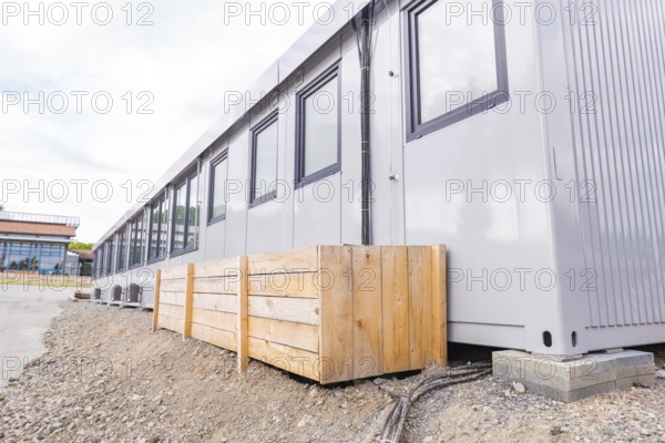 Side view of a modular building with timber panelling and windows, transitional daycare centre in
