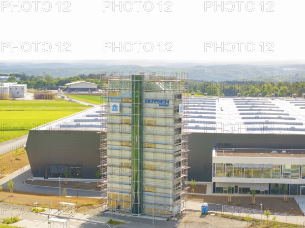 Front view of an industrial building with scaffolding and fields in the background, ING Park
