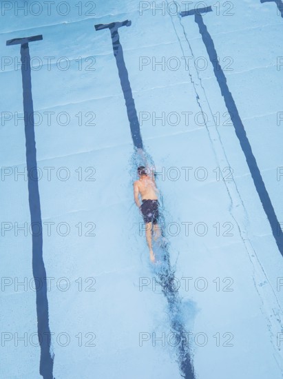 A swimmer in a large pool, concentrating on swimming his laps, Calw outdoor pool, Black Forest,