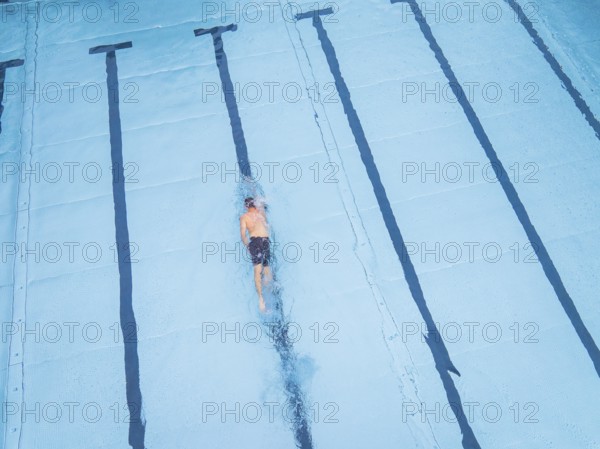 A single swimmer in the pool, calmly and steadily swimming his laps, Calw outdoor pool, Black