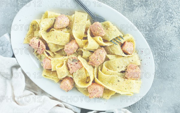 Papardelle pasta, in creamy sauce with salmon, natural light, lifestyle, homemade, on a gray