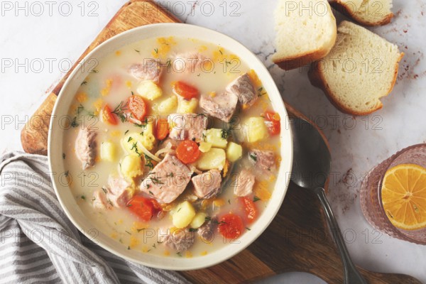 A bowl of soup on a light background, Finnish fish soup, lohikeito soup, creamy fish soup